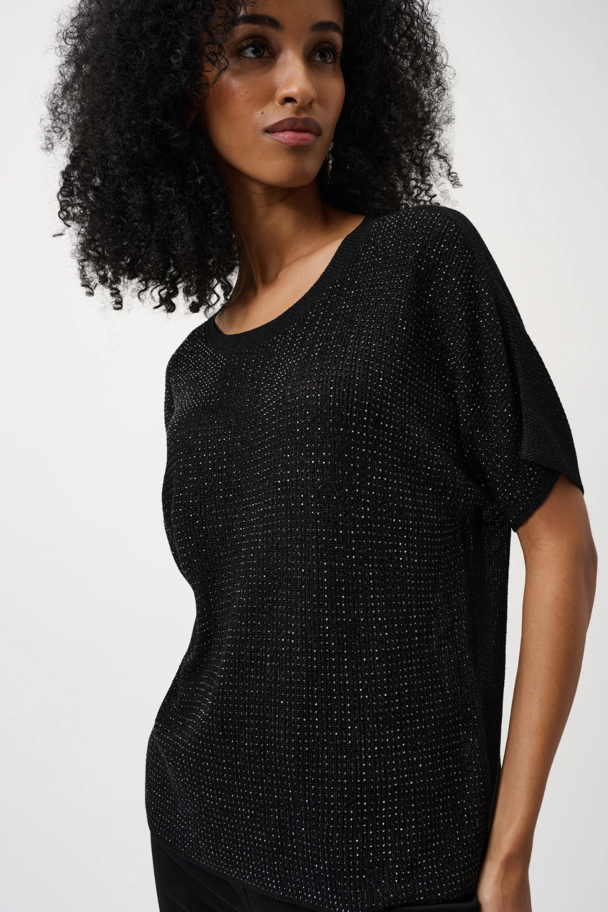 Woman wearing a black textured top against a white background