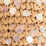 Close-up of woven material with embedded round, multicolored sequins.