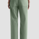 A person shown from the back wearing sage green wide-leg cropped jeans with black sandals, against a light gray studio background.