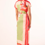 Woman wearing a colorful dress with a floral pattern on a white background