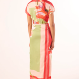 Woman wearing a colorful dress with a floral pattern on a white background