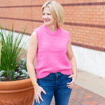 Sleeveless crew neck knit sweater styled with neutral bottoms.
