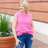 Sleeveless crew neck knit sweater styled with neutral bottoms.