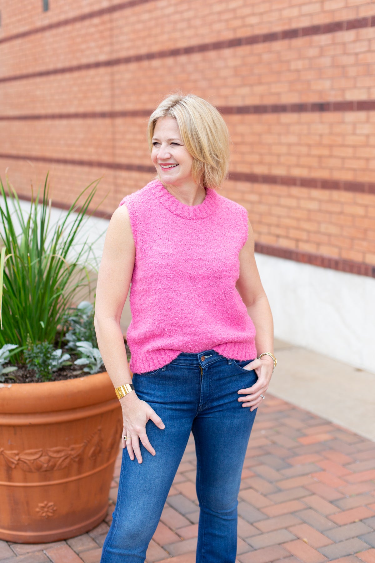 Sleeveless crew neck knit sweater styled with neutral bottoms.