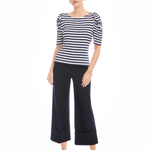 Woman wearing a black and white striped top and navy wide-leg pants on a white background