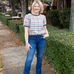 Tweed top with a structured silhouette in neutral tones.