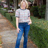 Tweed top with a structured silhouette in neutral tones.