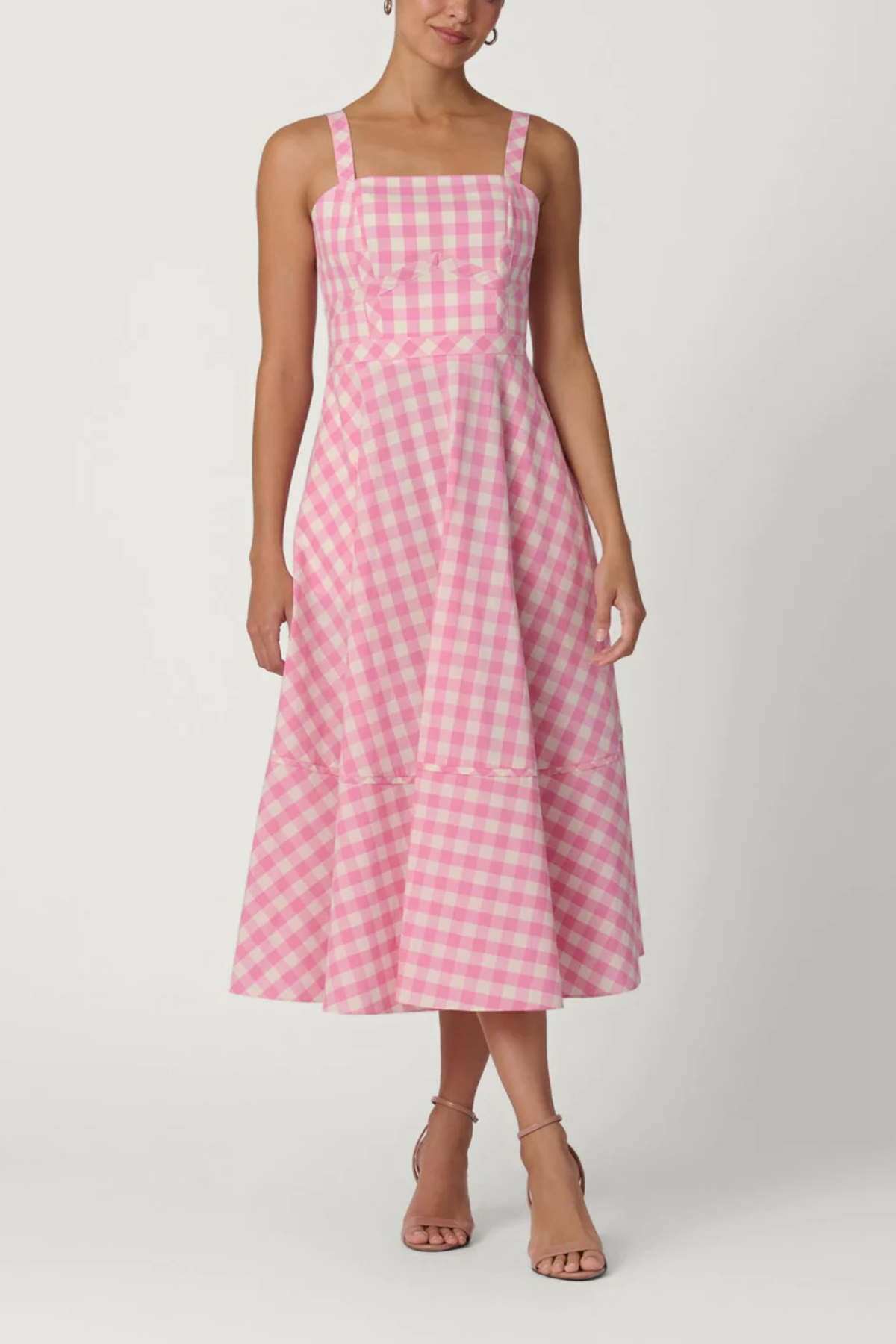 Woman wearing a pink and white checkered dress on a white background