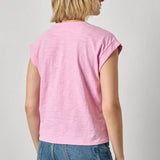 Person wearing a pink sleeveless top and blue jeans on a plain background