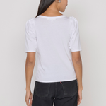 Person wearing a white t-shirt and black pants on a plain background