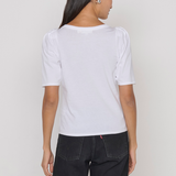 Person wearing a white t-shirt and black pants on a plain background