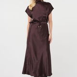 A woman modeling a dark brown short-sleeve midi dress with a high mock neck, drawstring waist, and subtle sheen, paired with black ankle boots against a plain white studio background.