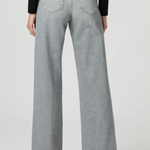 A person shown from the back wearing light gray wide-leg jeans, a black long-sleeve top, and black heels against a plain light gray studio background.