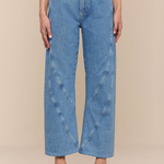 Person wearing blue jeans on a beige background
