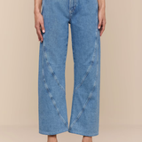 Person wearing blue jeans on a beige background