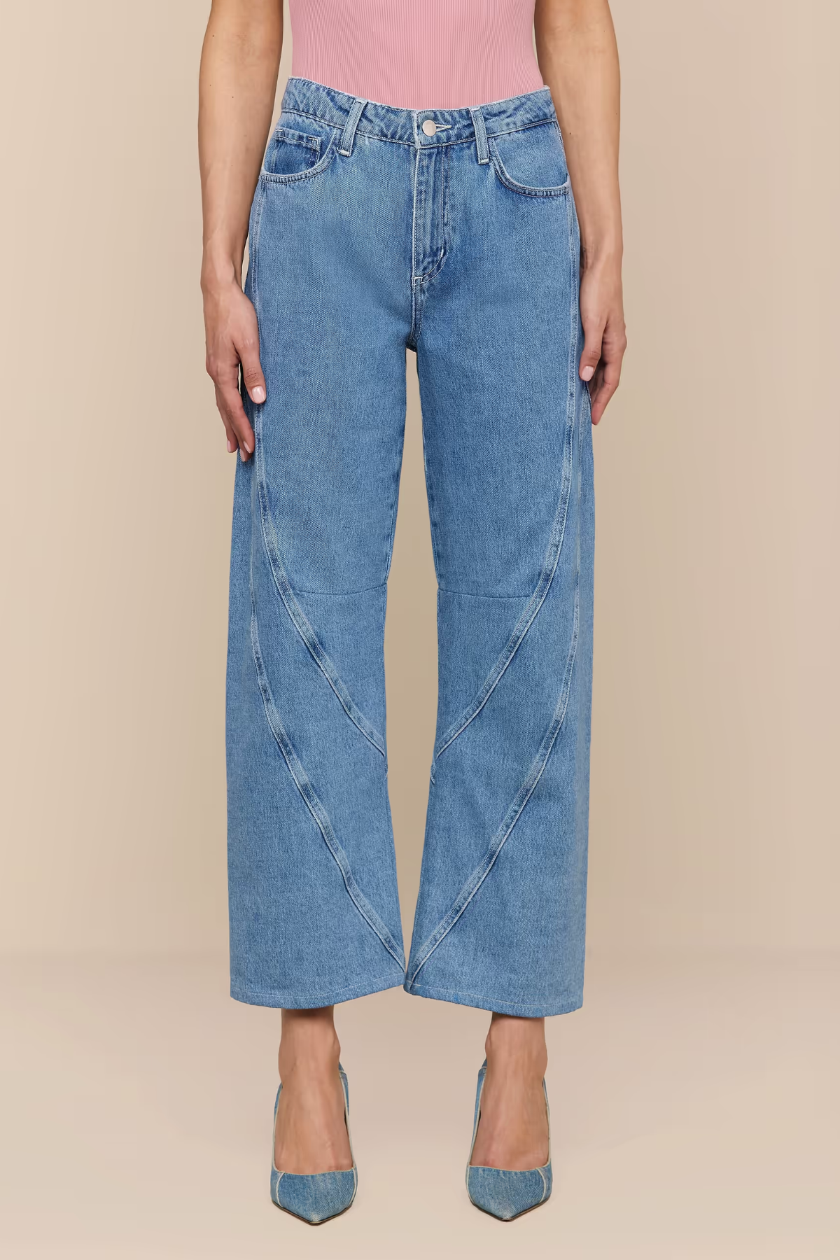 Person wearing blue jeans on a beige background