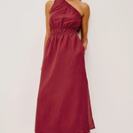 Woman wearing a burgundy one-shoulder dress on a white background