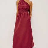 Woman wearing a burgundy one-shoulder dress on a white background