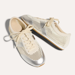 Pair of silver and cream sneakers on a white background