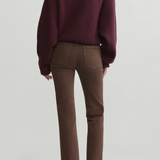 A model shown from the back wearing a dark burgundy knit sweater and brown ankle-length pants, paired with dark brown pointed-toe flats, against a light gray studio background.