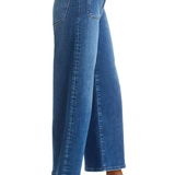 A side profile view of a model wearing blue wide-leg cropped jeans with black slingback heels, shown against a plain white background.