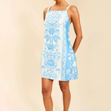 Woman wearing a blue floral dress on a beige background