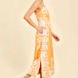 side view of woman inn orange embroidered midi dress 