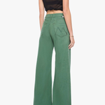 A woman shown from the back wearing green wide-leg pants, a black sleeveless crop top, and metallic high heels against a plain light gray studio background.