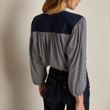 Neutral long-sleeve top styled casually with denim