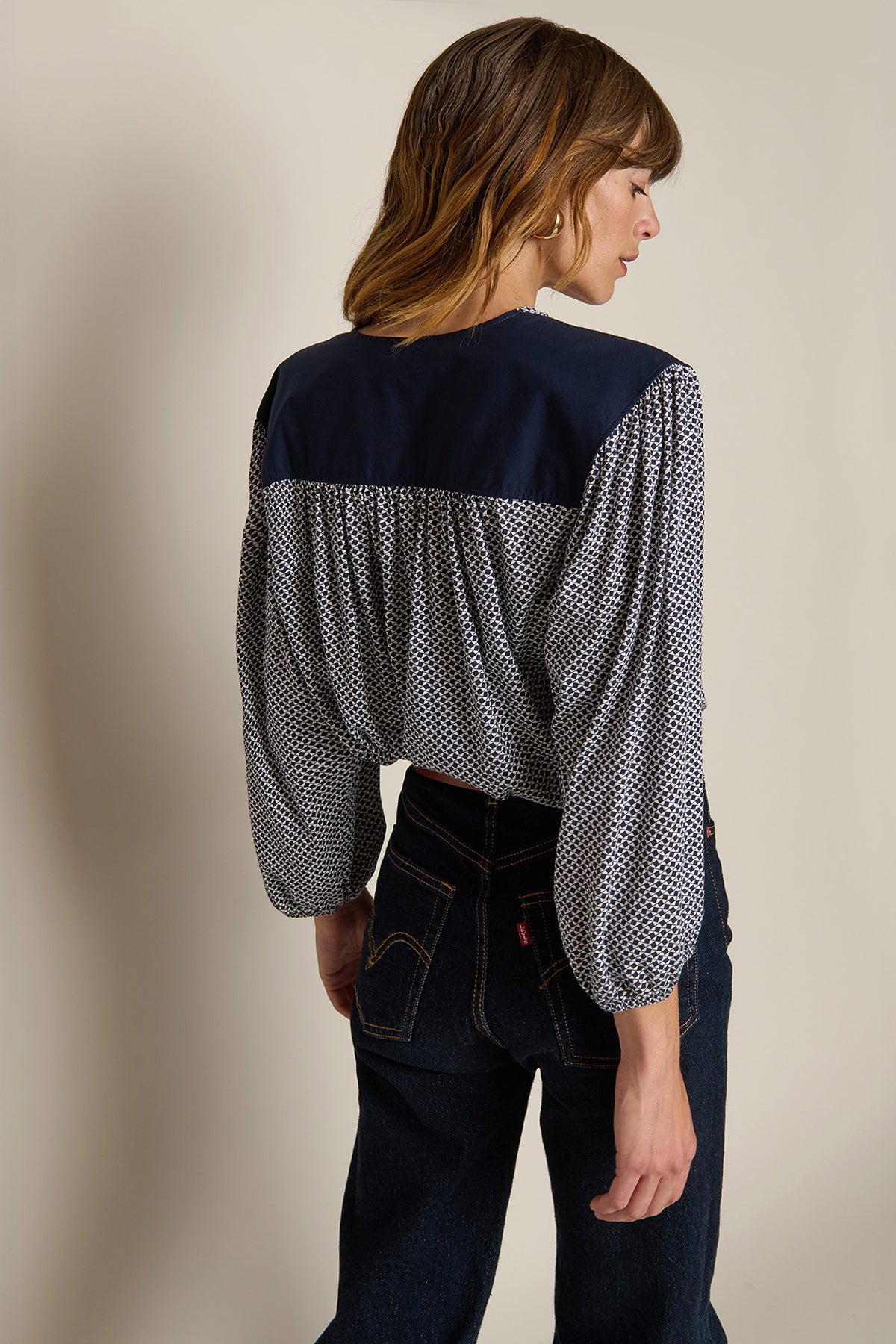 Neutral long-sleeve top styled casually with denim