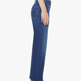 Person wearing blue jeans and blue shoes on a white background