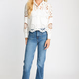 Woman wearing a white lace blouse and blue jeans on a white background