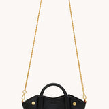 Black Hammitt Paul Mini crossbody bag worn with an evening outfit.
