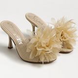 Beige high-heeled shoes with floral decorations on a white background