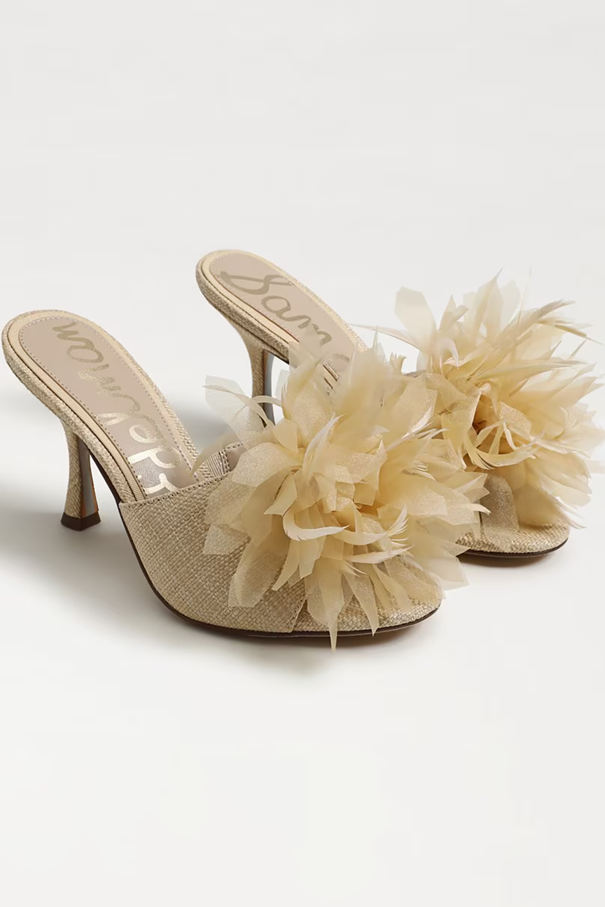 Beige high-heeled shoes with floral decorations on a white background