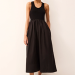 Woman wearing a black sleeveless dress against a white background