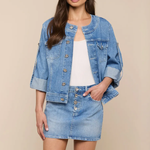 Woman wearing a denim jacket and skirt on a beige background