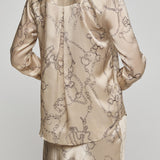 Beige satin pajama set with intricate patterns on a plain background