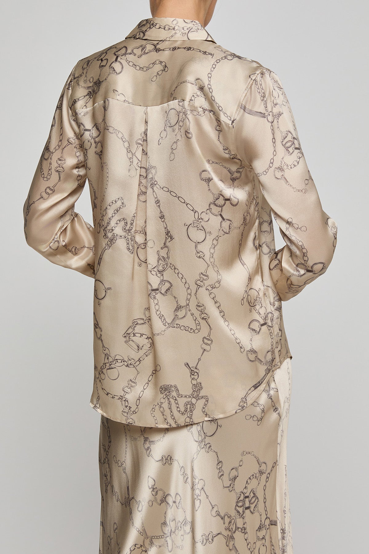 Beige satin pajama set with intricate patterns on a plain background