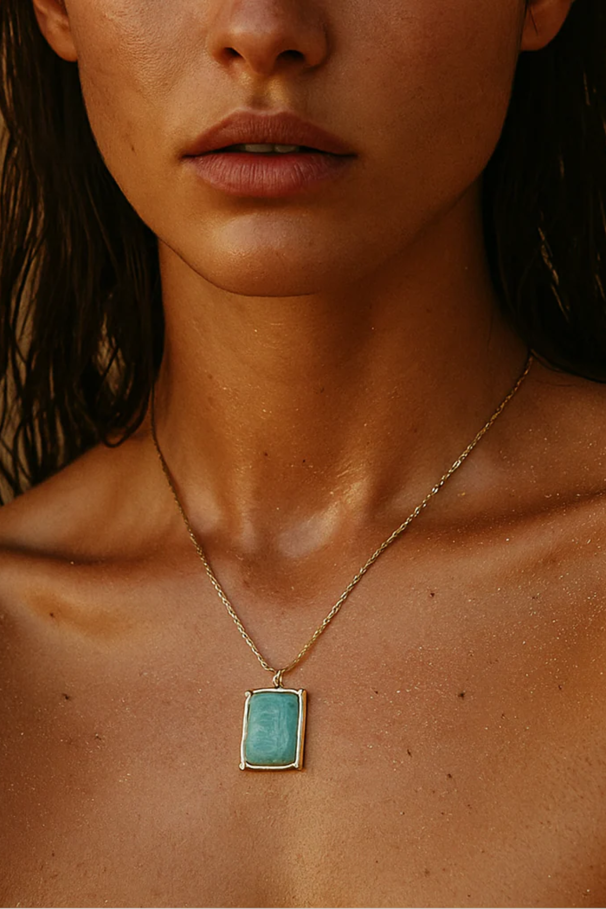 Close-up of a person wearing a gold necklace with a turquoise pendant.