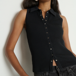 Woman wearing a black sleeveless button-up top against a white background
