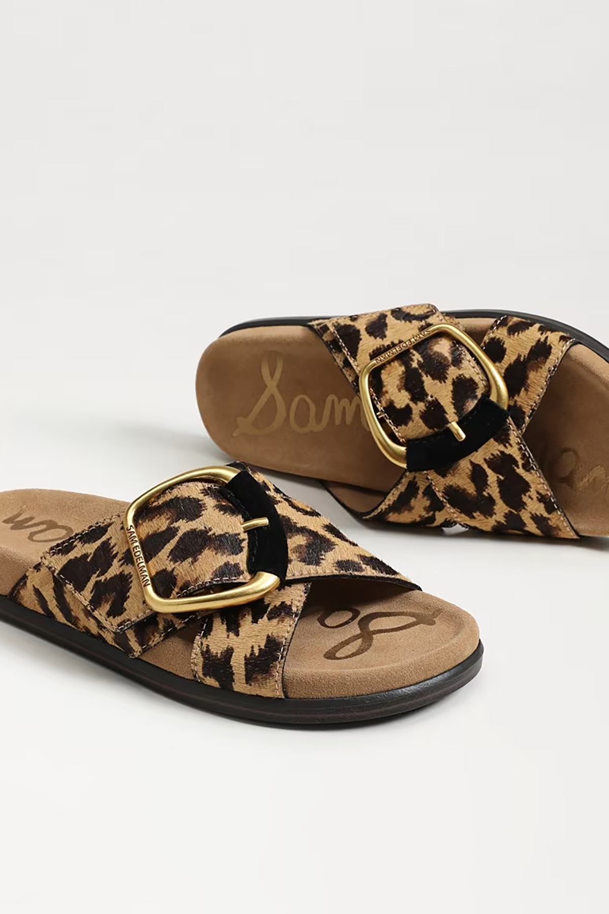 Leopard print sandals with gold buckles on a white background