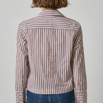 A person shown from the back wearing a cropped long-sleeve button-up shirt with vertical brown and white stripes, paired with blue jeans, against a light gray studio background.