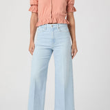 Woman wearing a pink blouse and light blue jeans on a white background