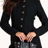 Black Hammitt Paul Mini crossbody bag worn with an evening outfit.