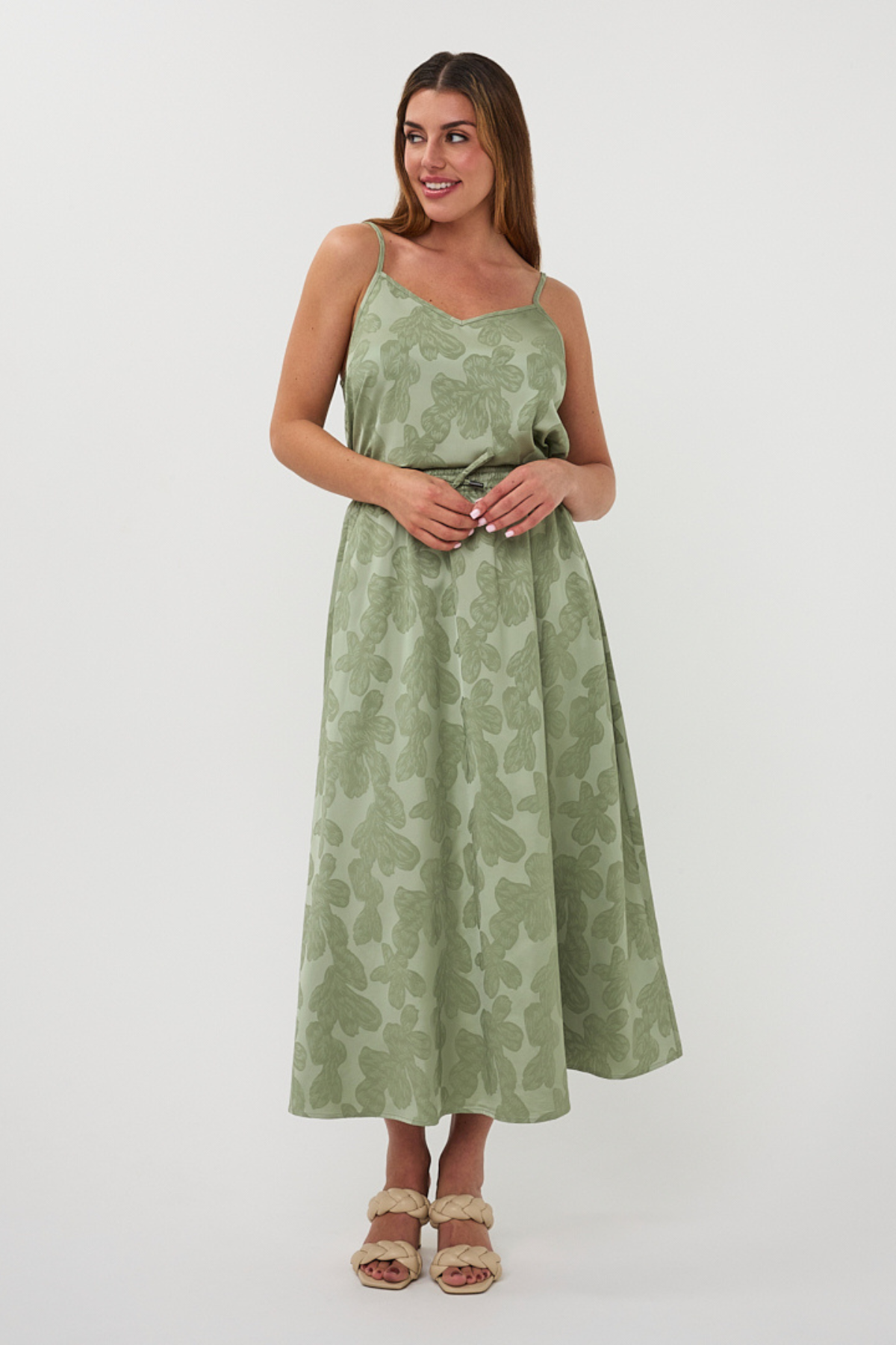 Woman wearing a green floral dress on a white background
