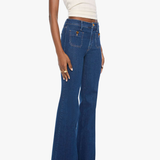 A model wearing a pair of high-waisted, wide-leg blue denim jeans with a cream ribbed tank top, shown from a side profile against a light gray background.