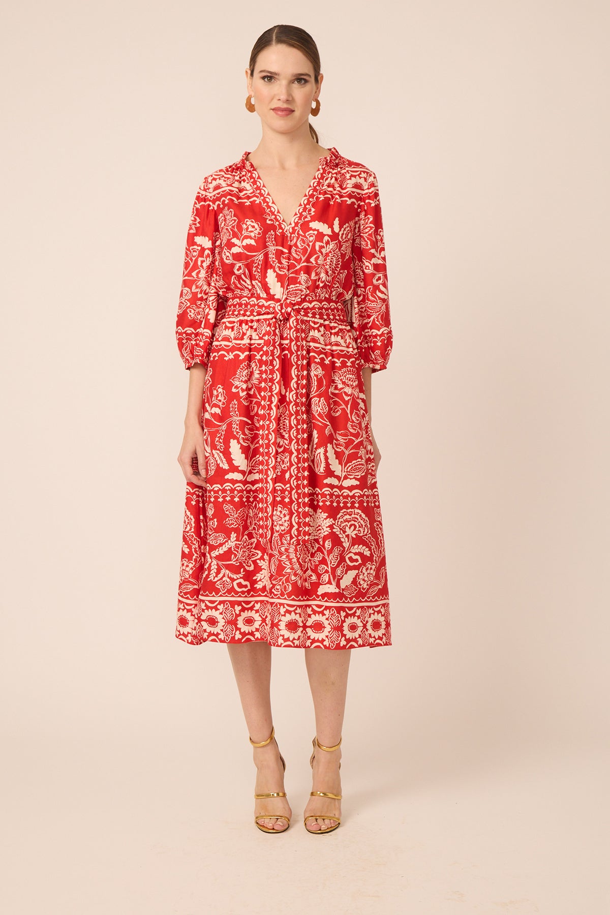 Woman wearing a red patterned dress on a beige background