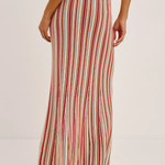 Woman wearing a red and white striped skirt on a plain background