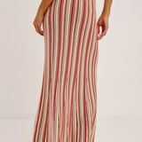 Woman wearing a red and white striped skirt on a plain background